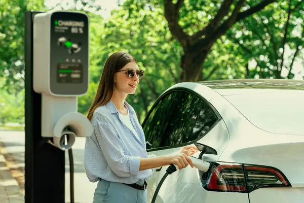 Happy driver charging electric vehicle